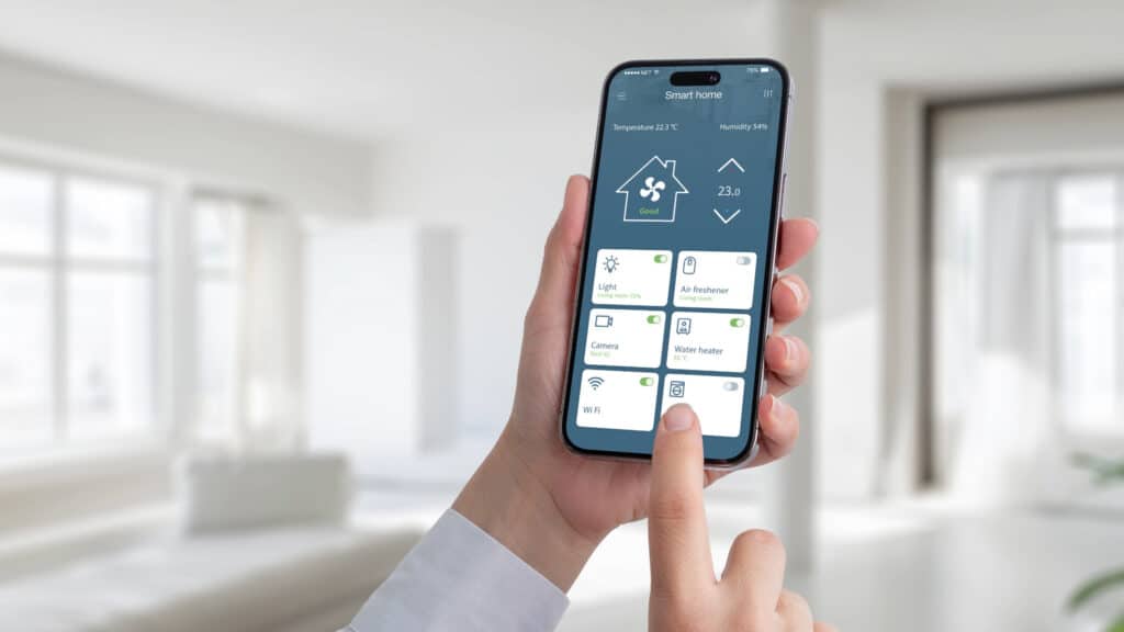Ein Smartphone zeigt eine Smart Home Steuerungs-App mit Temperatur und Luftfeuchtigkeit.