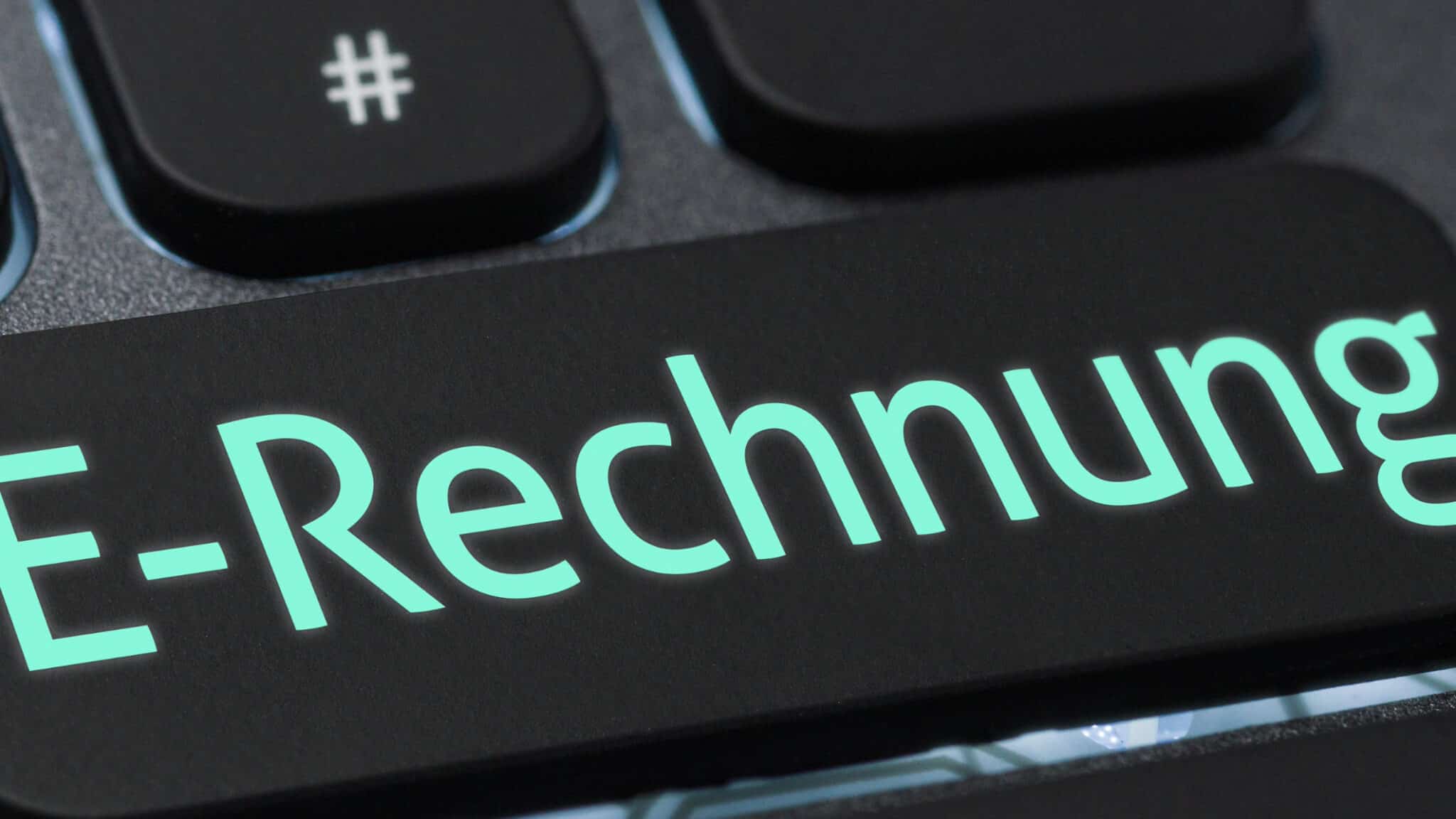E-Rechnung auf schwarzer Oberfläche mit türkisfarbenem Schriftzug und Hashtag-Symbol, passend zu AHW und dem Thema E-Rechnungen – Quo Vadis?